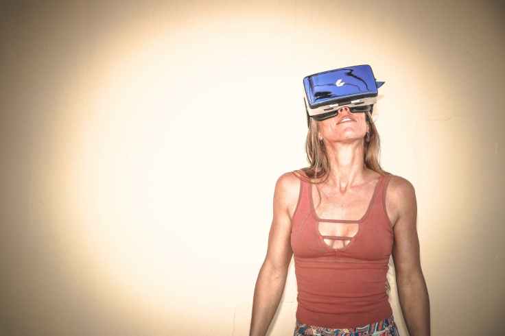 woman in brown cages sleeveless top and blue virtual reality headset